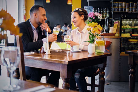 Loving black American couple on a date drinking wine in a restaurant.のeditorial素材