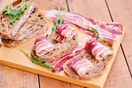 Bread with gourmet meat on a wooden desk.の写真素材