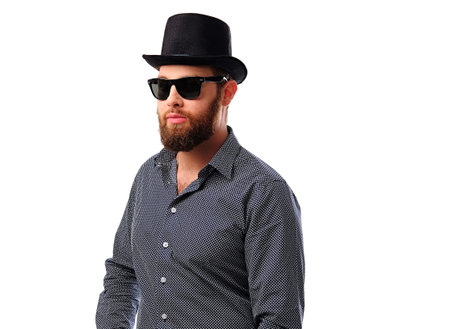 Studio portrait of bearded hipster male in sunglasses and cylinder hat isolated on a white background.の写真素材