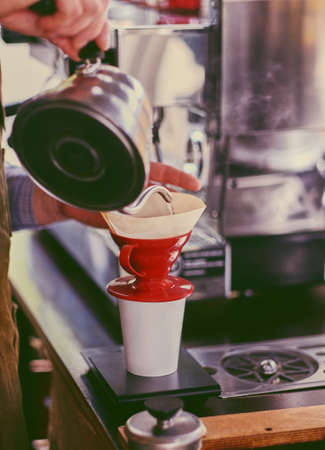 Close up image of a man preparing late in a coffee machine.の写真素材