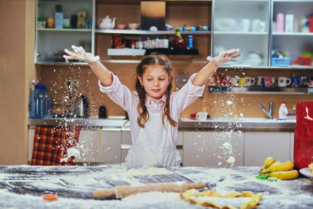 Cheerful little girl posing in the kitchen.の写真素材