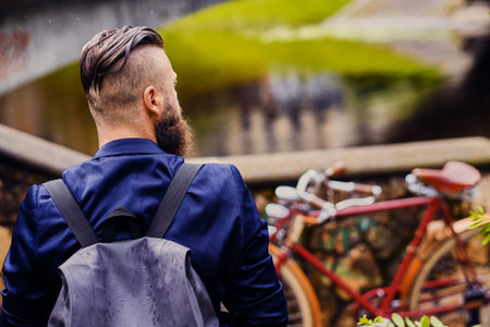 Casual modern guy with backpack. Back view.