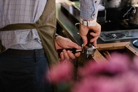 Close up image of male preparing coffee in a coffee machine.