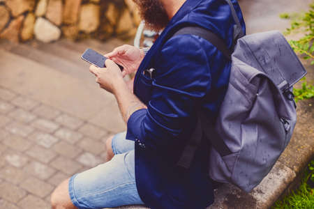 Traveller male speaking by a smartphone. Back view.の写真素材