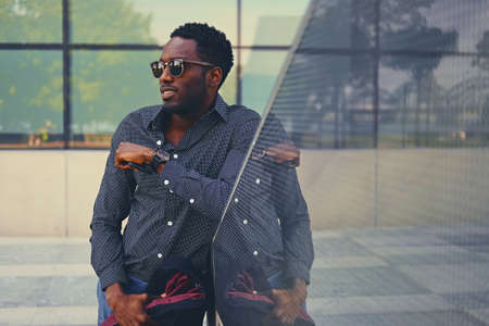 Stylish Black American male over modern building background.の写真素材