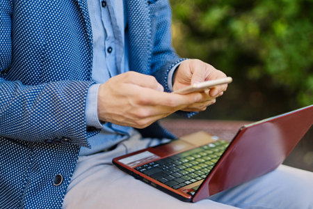 Handsome bearded male using laptop in a park.