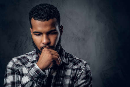 Dramatic portrait of Black pensive male over dark grey background.の写真素材