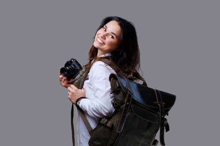 Positive female tourist with photo camera and travel backpack.の写真素材