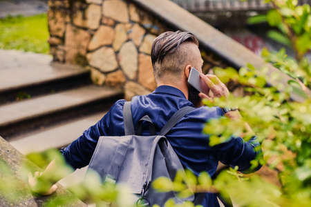 Traveller male speaking by a smartphone. Back view.の写真素材