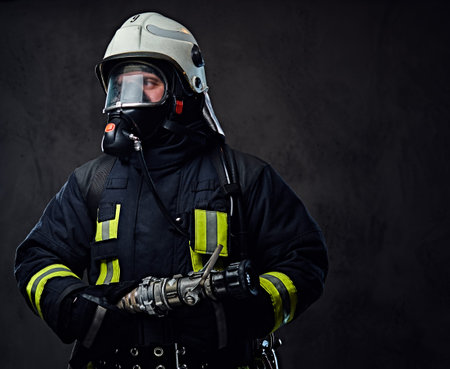 Studio portrait of firefighter dressed in uniform and an oxygen mask.