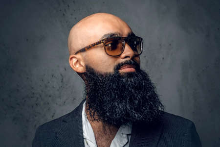 Close up studio portrait of Arabic bearded shaved head male in sunglasses.の写真素材