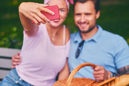 A couple on a date in a city park using smartphone and instant messaging.
