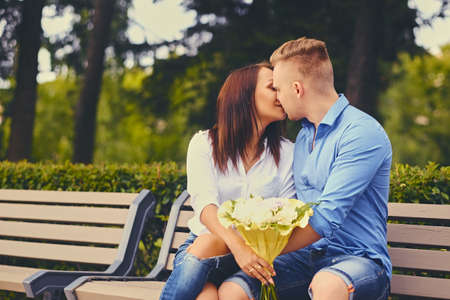 Attractive couple on a date. A man is giving a bouquet of flowers to his girlfriend.