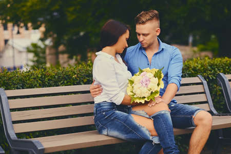 Attractive couple on a date. A man is giving a bouquet of flowers to his girlfriend.の写真素材