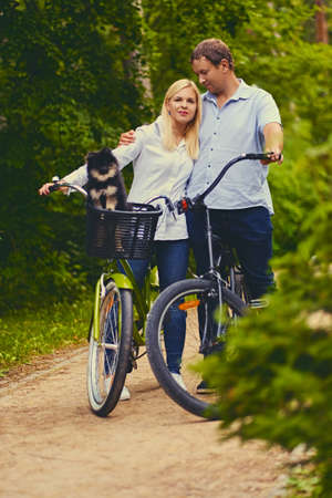 Blond female and a man on a bicycle ride in a park.の写真素材