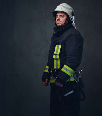 Studio portrait of firefighter dressed in uniform and safety helmet.の写真素材
