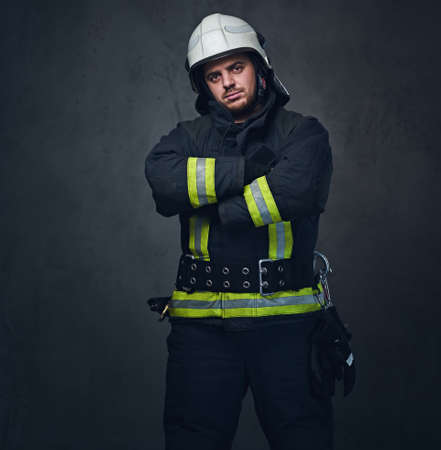 Studio portrait of firefighter dressed in uniform and safety helmet.の写真素材