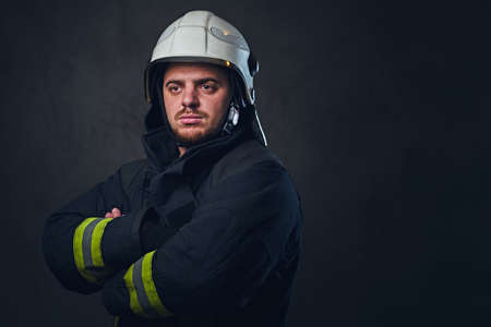 Studio portrait of firefighter dressed in uniform and safety helmet.の写真素材