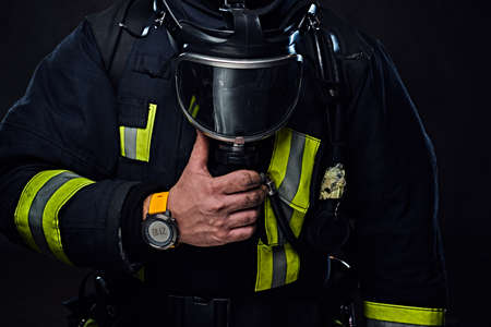 Studio portrait of a male dressed in a firefighter uniform holds an oxygen mask.の写真素材