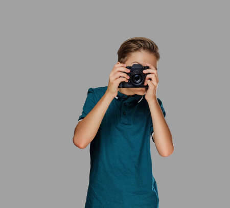 Teenager boy taking pictures with a professional camera.の写真素材