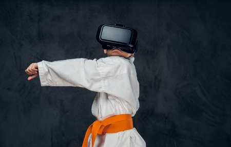 Little boy dressed in a white kimono with VR glasses on his head.の写真素材