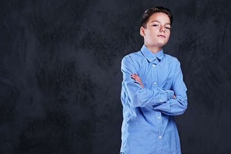 Studio portrait of a teenage boy with crossed arms on a chest.の写真素材