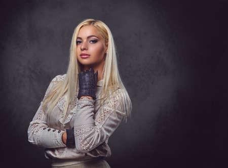 Studio portrait of old fashioned blonde female on grey background.の写真素材