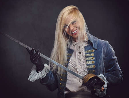 An attractive blonde female dressed in medieval urban clothes holds a silver sword over grey...