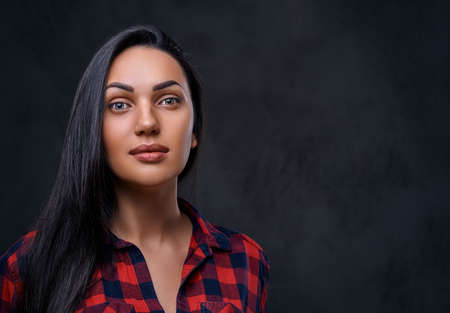 Studio portrait of brunette glamour hipster female dressed in a red fleece shirt over grey...