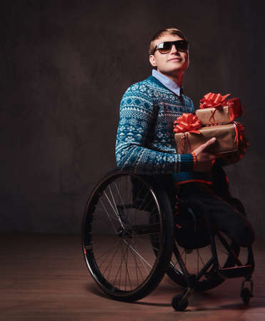 A man in wheelchair with Christmas gifts.