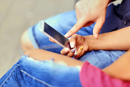 A couple on a date in a city park using smartphone and instant messaging.