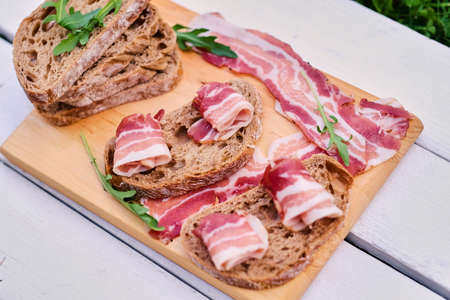 Bread with gourmet meat on a wooden desk.