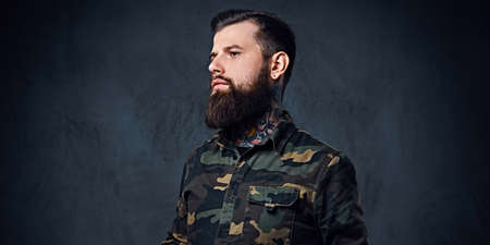Portrait of bearded tattooed hipster male dressed in a militaryの写真素材