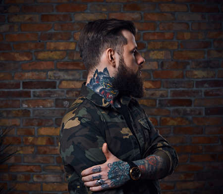 Tattooed bearded male in military jacket.