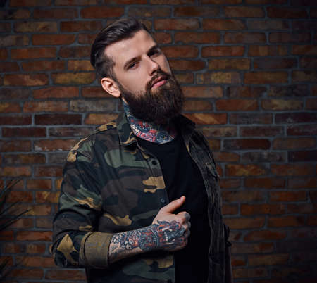 Tattooed bearded male in military jacket.の写真素材
