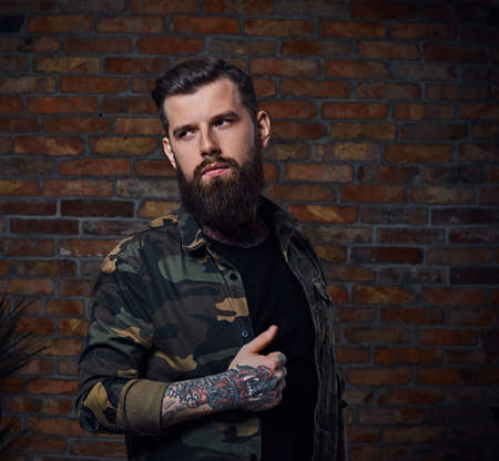 Tattooed bearded male in military jacket.の写真素材