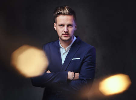 A man dressed in a suit over dark grey background.の写真素材