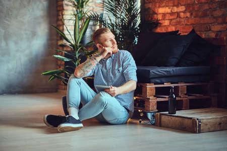 The full body image of blond stylish male using a tablet PC.の写真素材