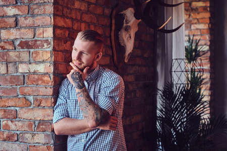 Portrait of a bearded modern male with tattoos on his arms.の写真素材