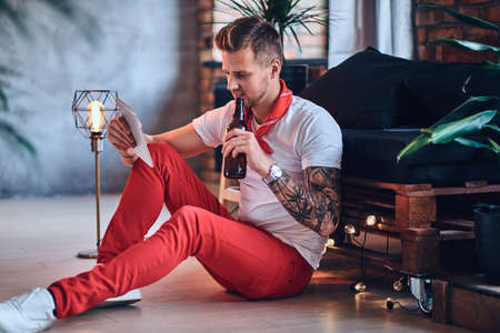A man using tablet PC in a room with loft interior.の写真素材