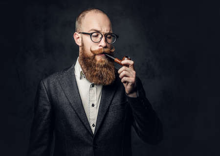 A man smoking pipe over grey background.の写真素材