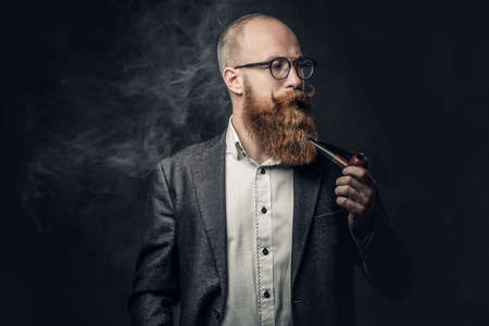 A man smoking pipe over grey background.の写真素材