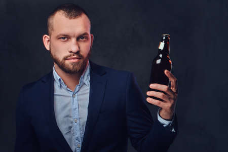 A man dressed in an elegant suit holds craft beer.