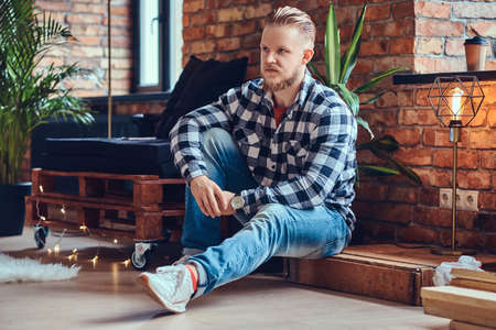 A blond bearded hipster male dressed in a jeans and fleece shirtの写真素材