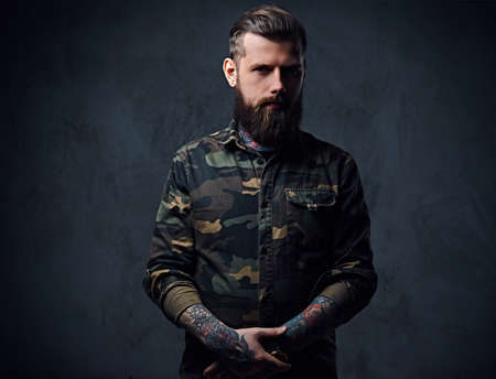 Portrait of bearded tattooed hipster male dressed in a militaryの写真素材