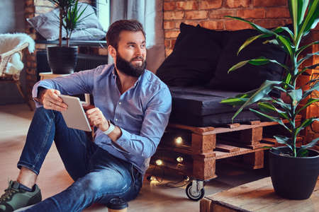 A man using tablet PC in a room.の写真素材