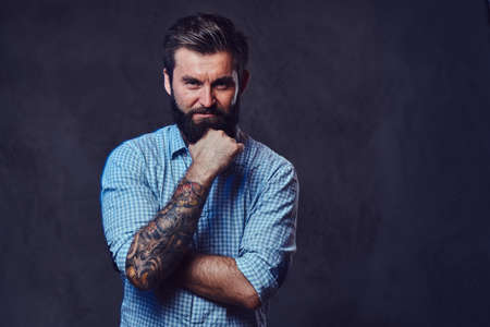 A man with tattoo on arm dressed in a shirt.の写真素材