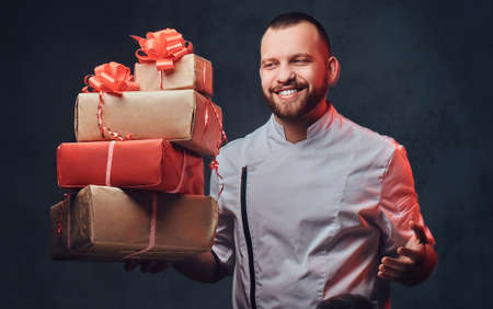 Chef cook holds colorful paper Christmas gifts.の写真素材