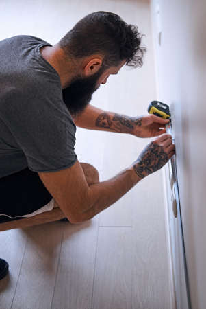 Carpenter measuring a wall.