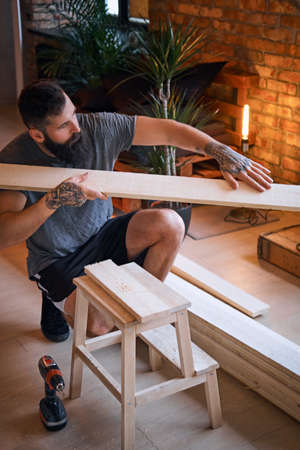 Carpenter checks the boards in a loft room.の写真素材